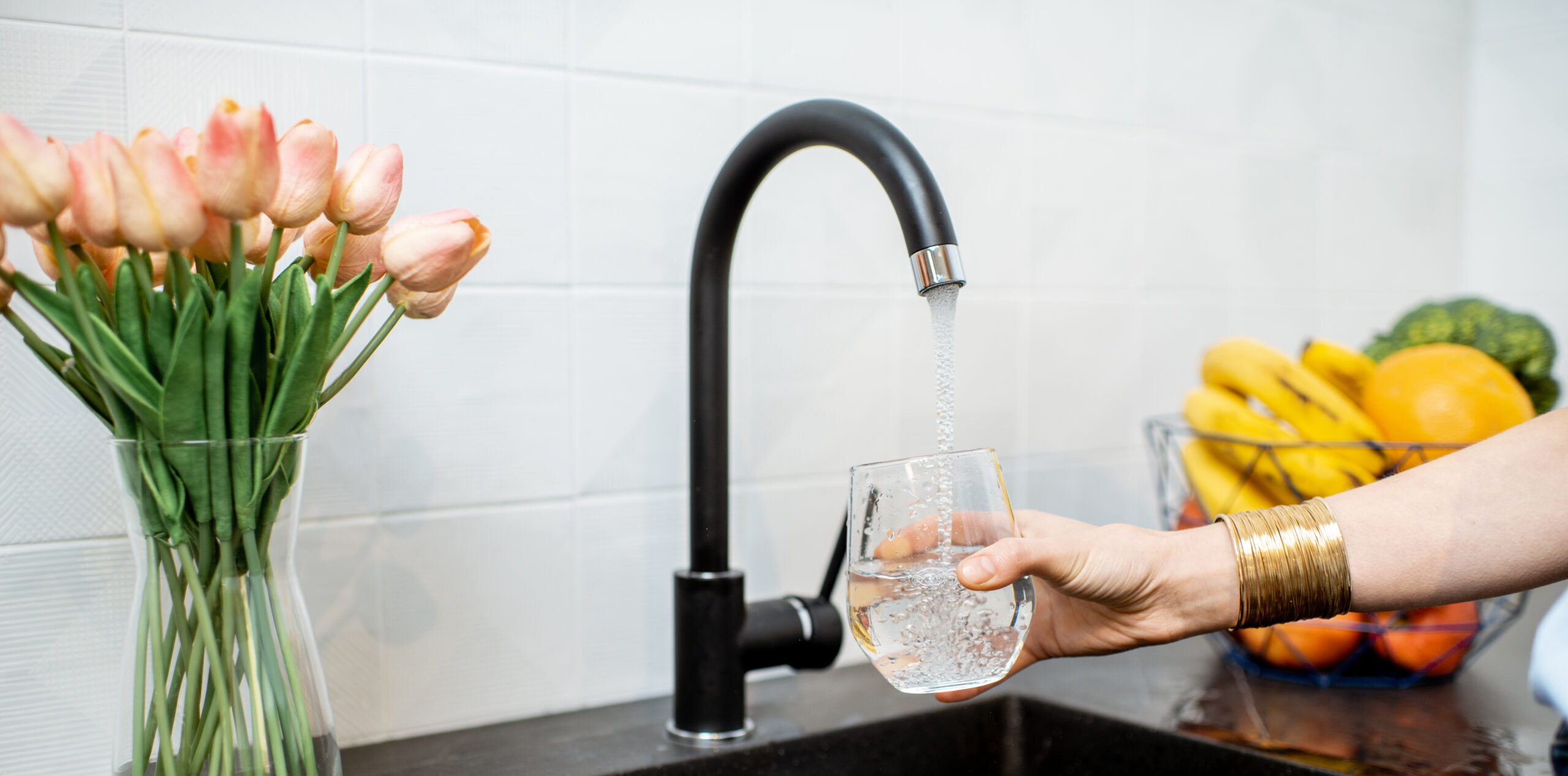Woman filling tap water in the kitchen
